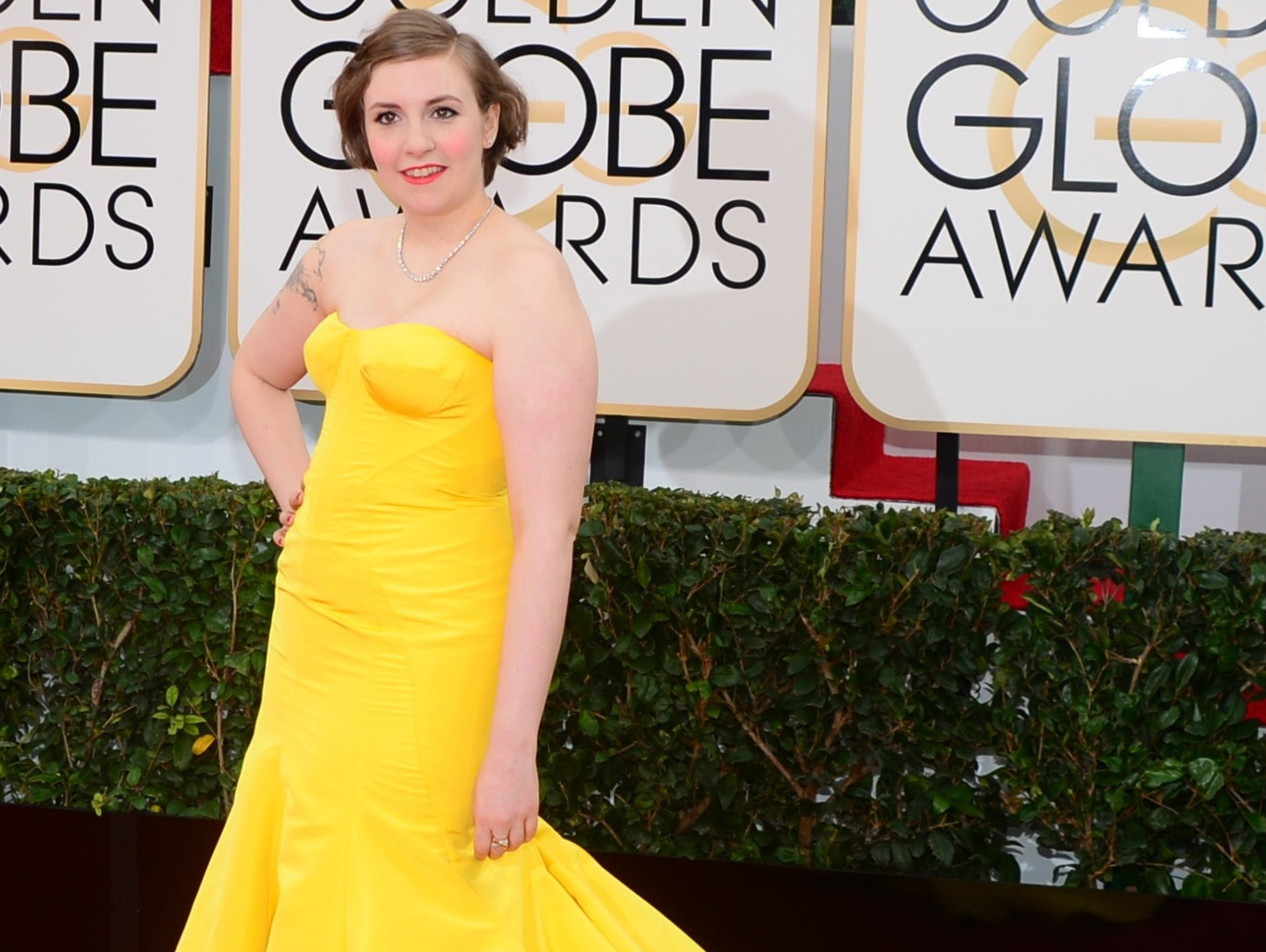 Actress and director Lena Dunham arrives in bright yellow on the red carpet for the Golden Globe awards in Beverly Hills, California, in 2014.