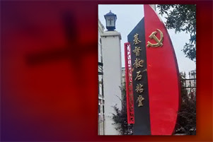 A sign in Chinese with a hammer and sickle beside it. 