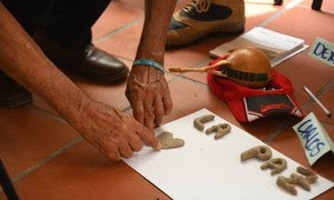 Participante en un programa de reconciliación de Colombia escribe la palabra paz.