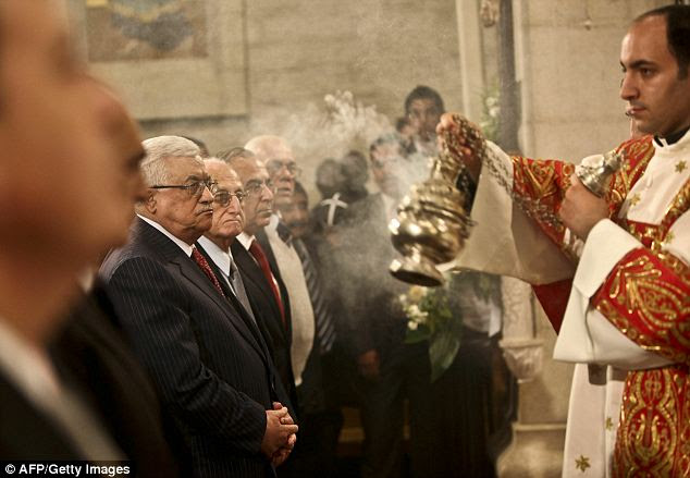 Palestinian president Mahmud Abbas (L) attends the midnight mass ceremony which marks the beginning of Christmas Day