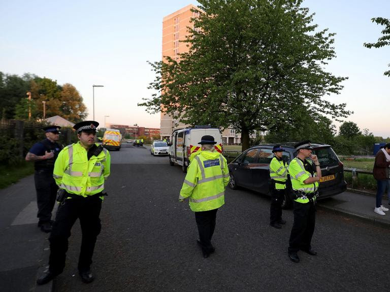 Police stand outside a block of flats in Blackley, Greater Manchester, where a woman was arrested in connection with the Manchester attack