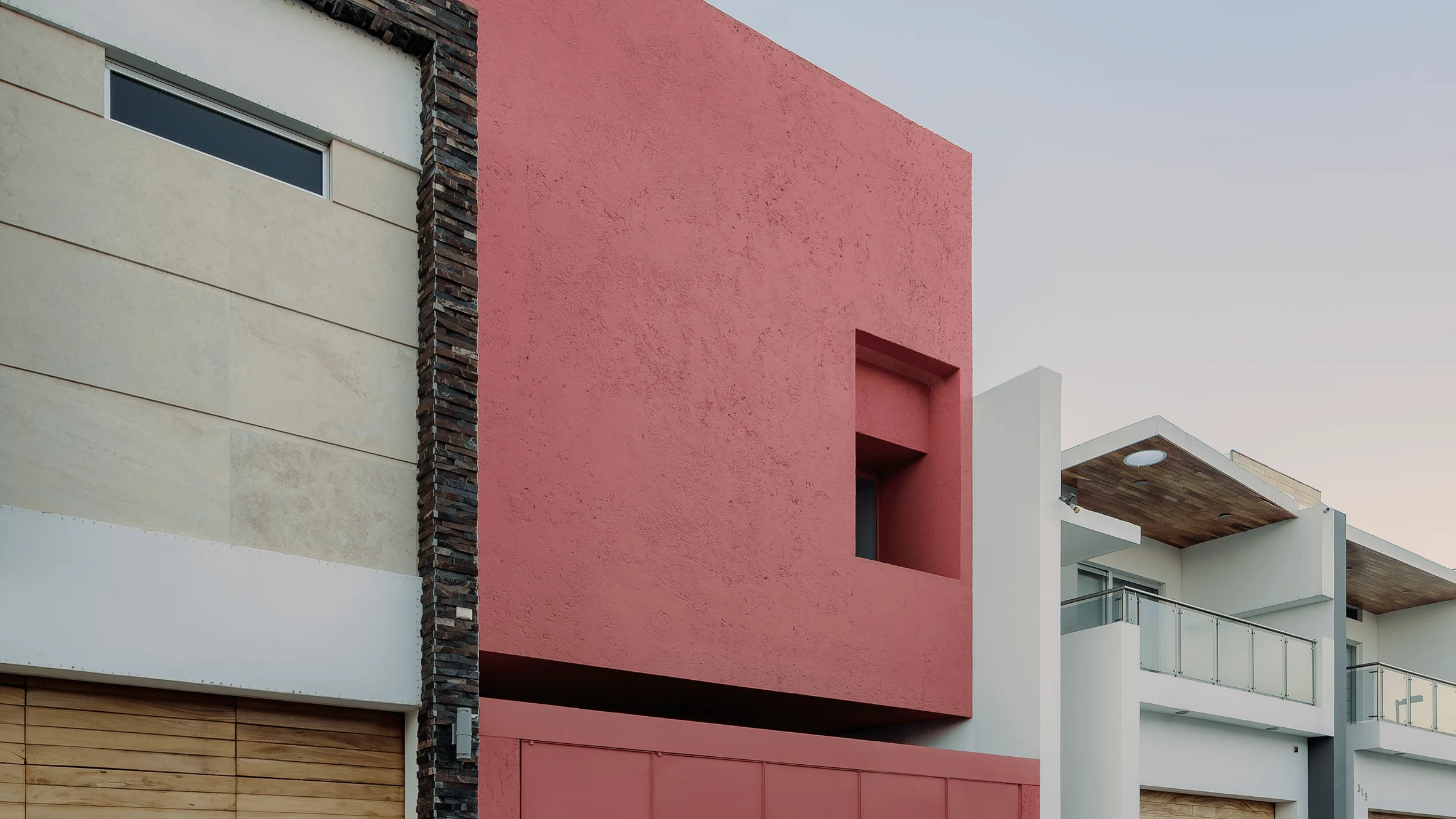 La vivienda rosa en Tres Ríos destaca por la sencillez de su fachada con respecto a la de sus vecinos.
