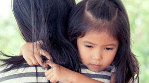 Image of young girl hugging a woman