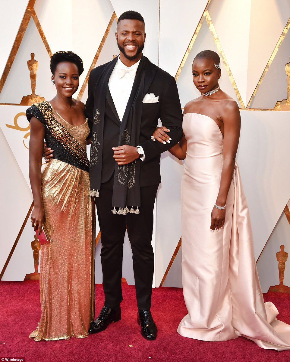 Talented group: The Black Panther beauty's ruched round-neck frock grazed the floor; she carried an on-trend clutch, adding diamond earrings and strappy black heels; pictured with Winston Duke and Danai Gurira