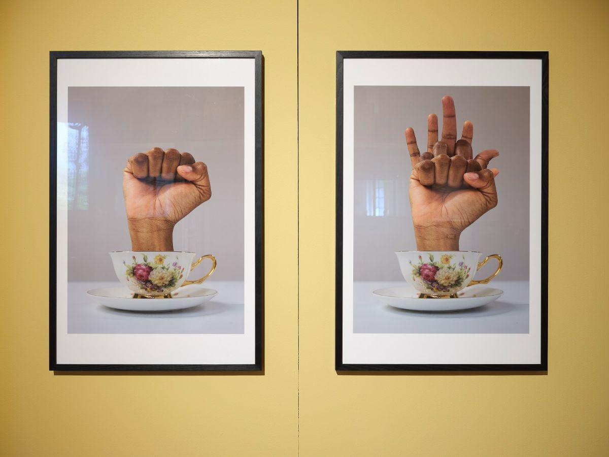 Two prints featuring fists emerging from teacups