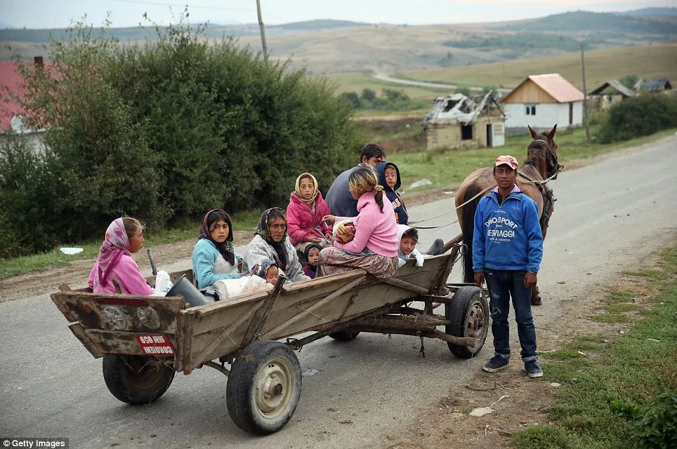 Exigences Médiévale: Les Roms s'arrêtent pour prendre des photos en chevauchant leurs calèches qui, pour de nombreux habitants, sont le principal moyen de transport dans les zones rurales