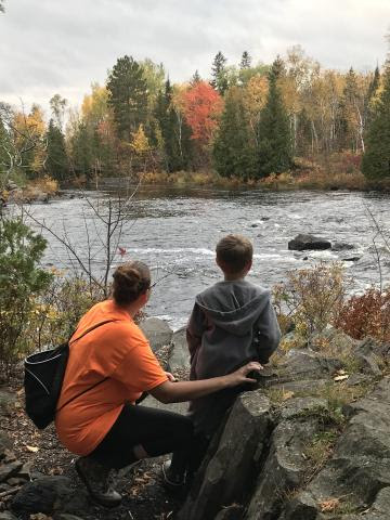 Pastor Pam Brown with a child overlooking stream