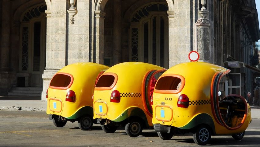 Three yellow Cocotaxis in a row in Havana