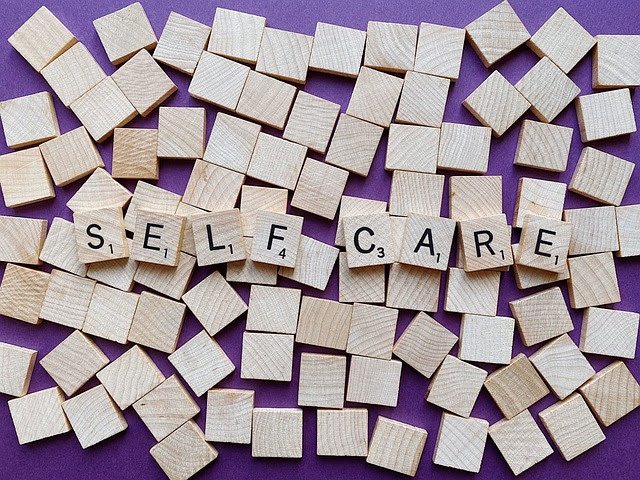 Scrabble tiles spelling out the words "self care".