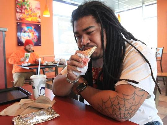 Jaren Cherry takes a bite of a Chipotle Chicken Loaded Griller at Taco Bell.