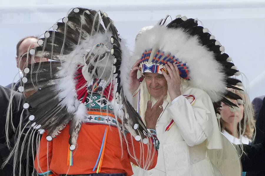 Pope Francis puts on an indigenous headdress during a meeting with indigenous communities, including First Nations, Metis and Inuit, at Our Lady of Seven Sorrows Catholic Church in Maskwacis, near Edmonton, Canada.