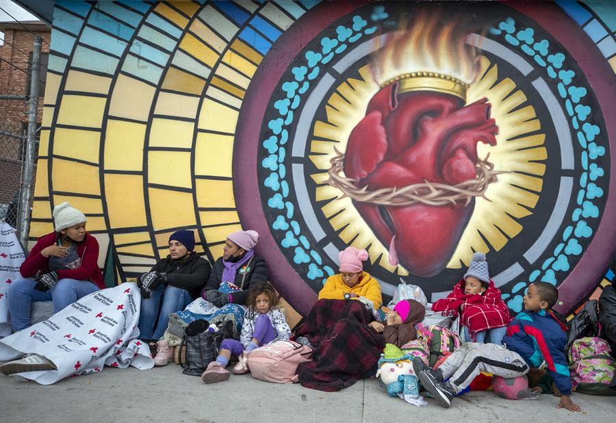 Migrants try to stay warm while camping outside the Sacred Heart Church in El Paso, Texas.