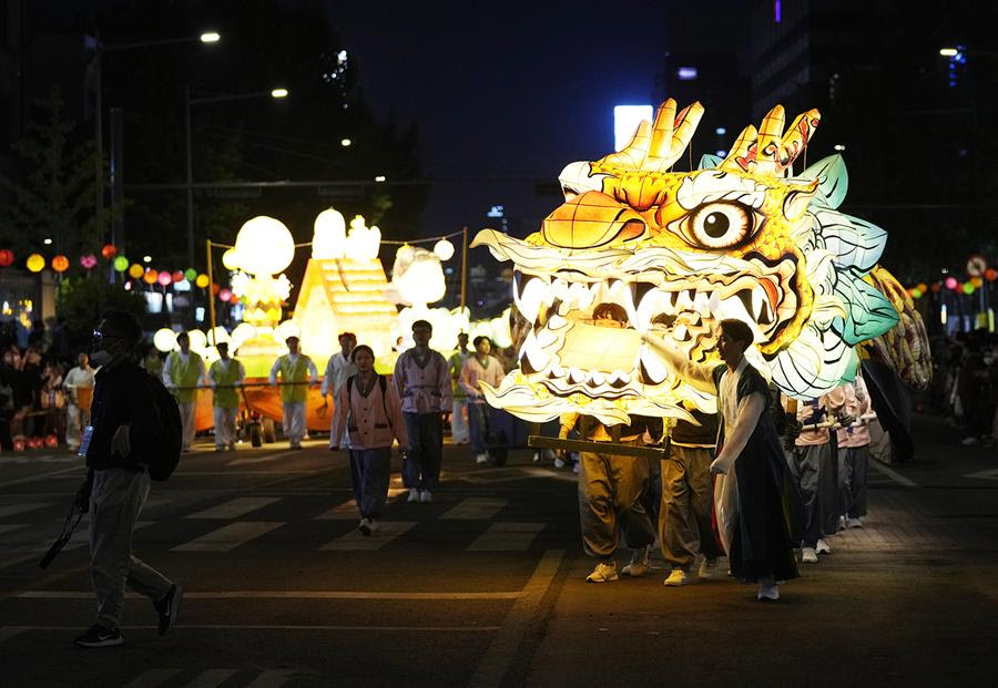 Buddhists march with a giant lantern shaped like a dragon in a parade during the Lotus Lantern Festival to celebrate the upcoming birthday of Buddha.