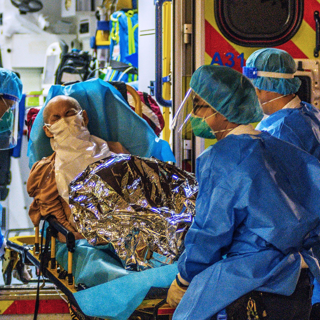 An elderly patient is transferred out of an ambulance by paramedics at Princess Margaret hospital, in Hong Kong.