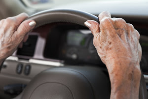 older woman's hands on steering wheel