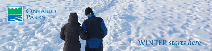 A man and women walking on a snow covered trail