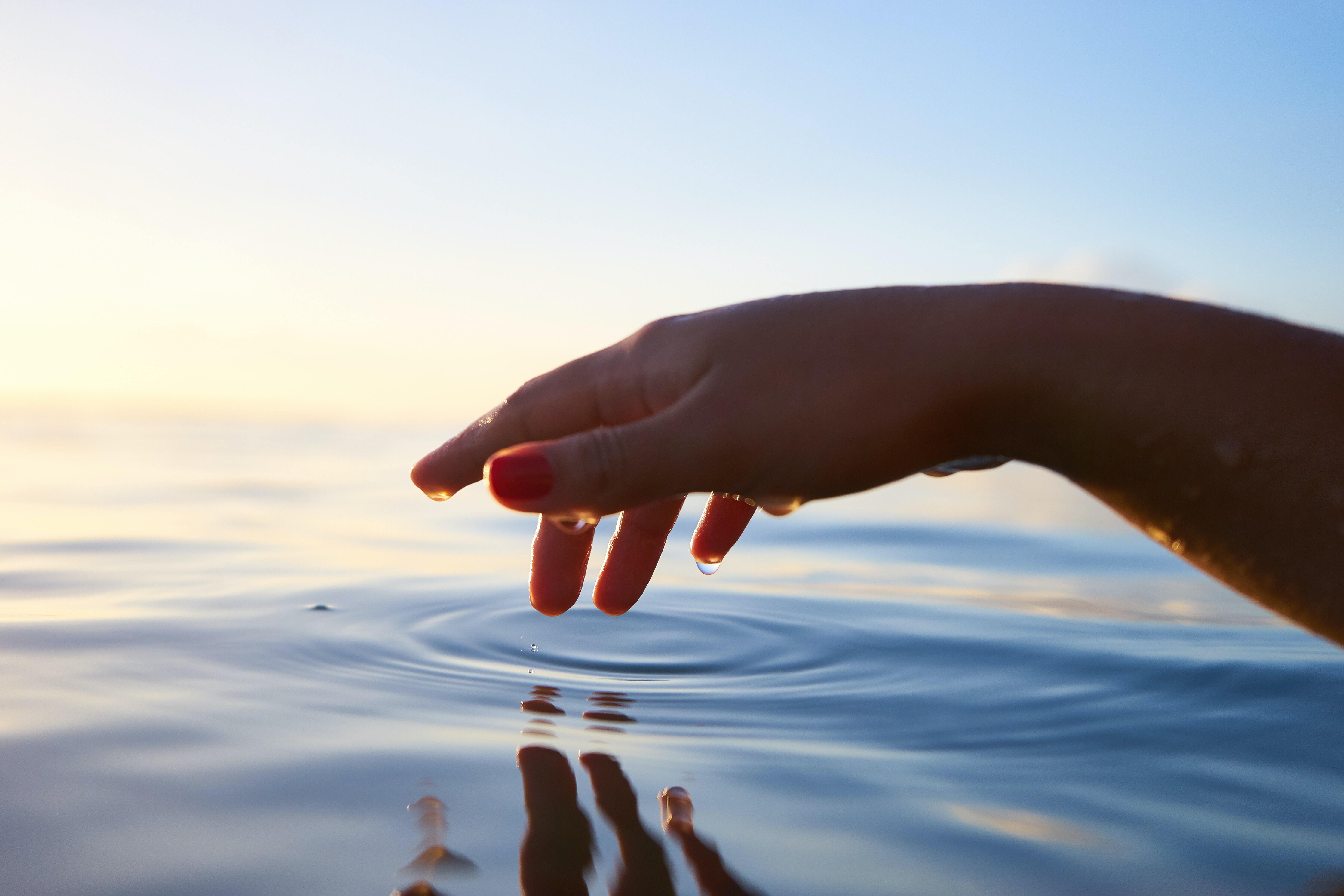 image of a hand touching water