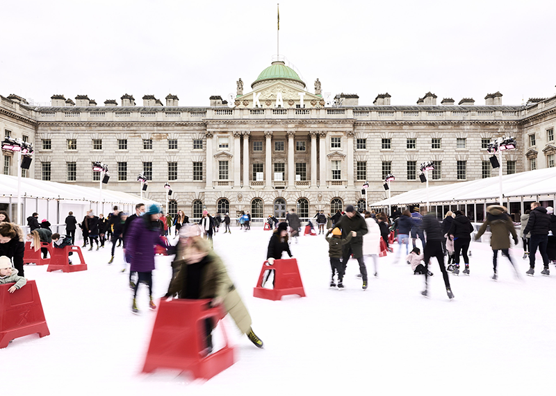 A photo of people enjoying themselves on the ice rink at Somerset House during the day.