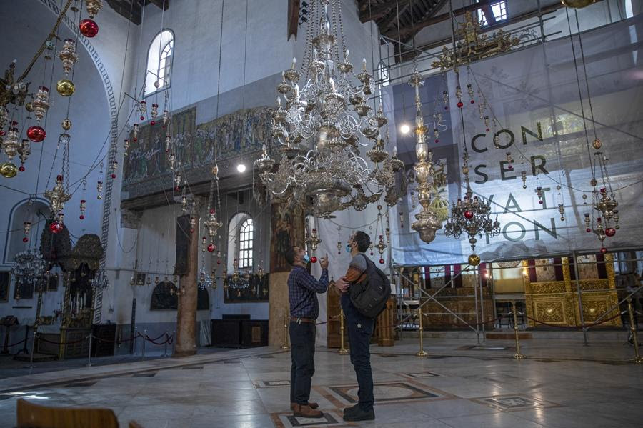 Tourists visit the Church of the Nativity, in the West Bank city of Bethlehem, Tuesday, Nov. 16, 2021. The Church of the Nativity, built on the spot where Christians believe Jesus was born, is wrapping up a three-year restoration project just in time for the normally busy Christmas season. While the region is finally welcoming foreign tourists after a year-and-a-half-long COVID shutdown, few travelers are making their way to the birthplace of Jesus this holiday season (AP Photo/Nasser Nasser)