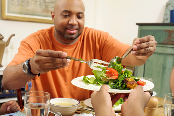 A man serving salad.