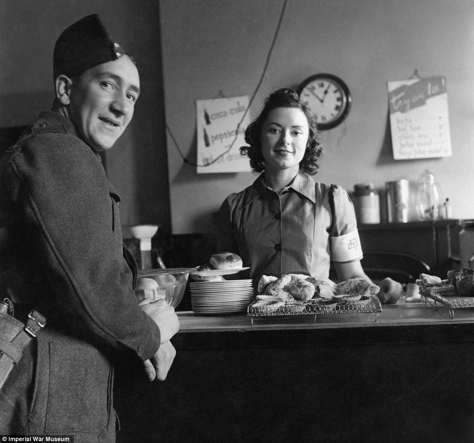 Down time: A soldier orders a cup of tea in the Forces Canteen at Victoria Station in 1942. The soldier pictured was the butler of a close friend of photographer Cecil Beaton