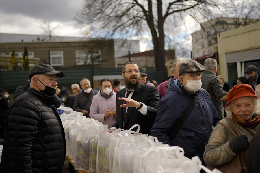 Rabbi Yehuda Teichtal, center, gives instructions during preparations for the celebration of Jewish Passover at the Chabad Jewish Education Center in Berlin, Germany, Thursday, April 7, 2022.