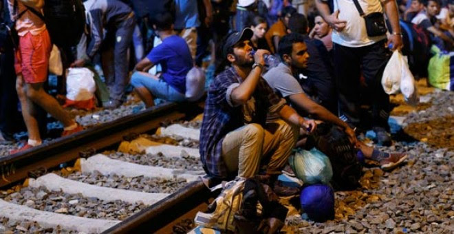 Un grupo de refugiados espera en la estación de la ciudad fronteriz de Tobarnik. / ANTONIO BRONIC (REUTERS)