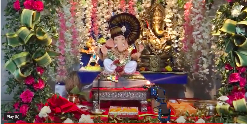 A statue of the Hindu god Ganesha with flowers around it.