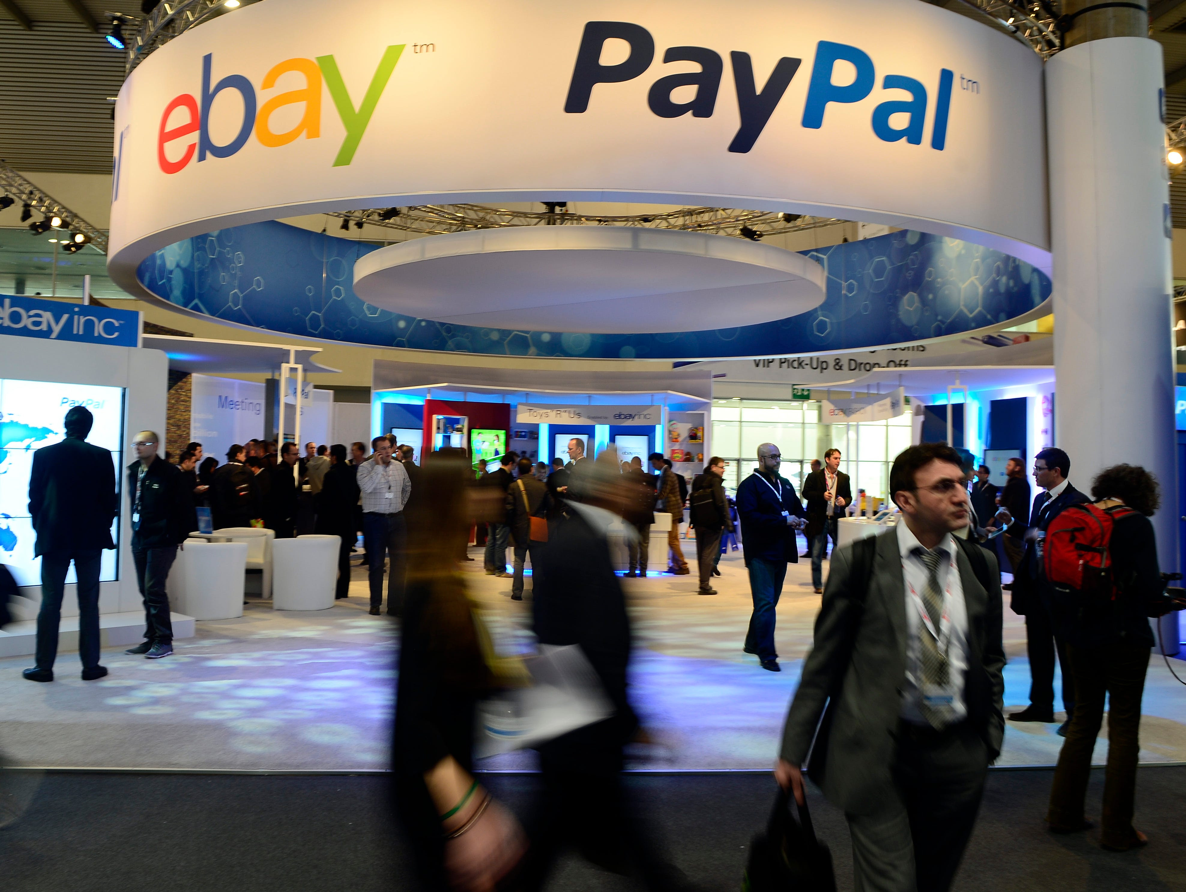 Attendees walk in front of an EBay and PayPal display area at the Mobile World Congress in 2013, the world's largest mobile phone trade show, in Barcelona, Spain.