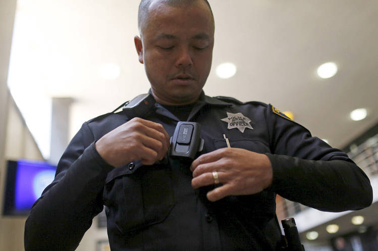 A police officer in Oakland, Calif., putting on a body camera, designed to record both audio and video in the field.