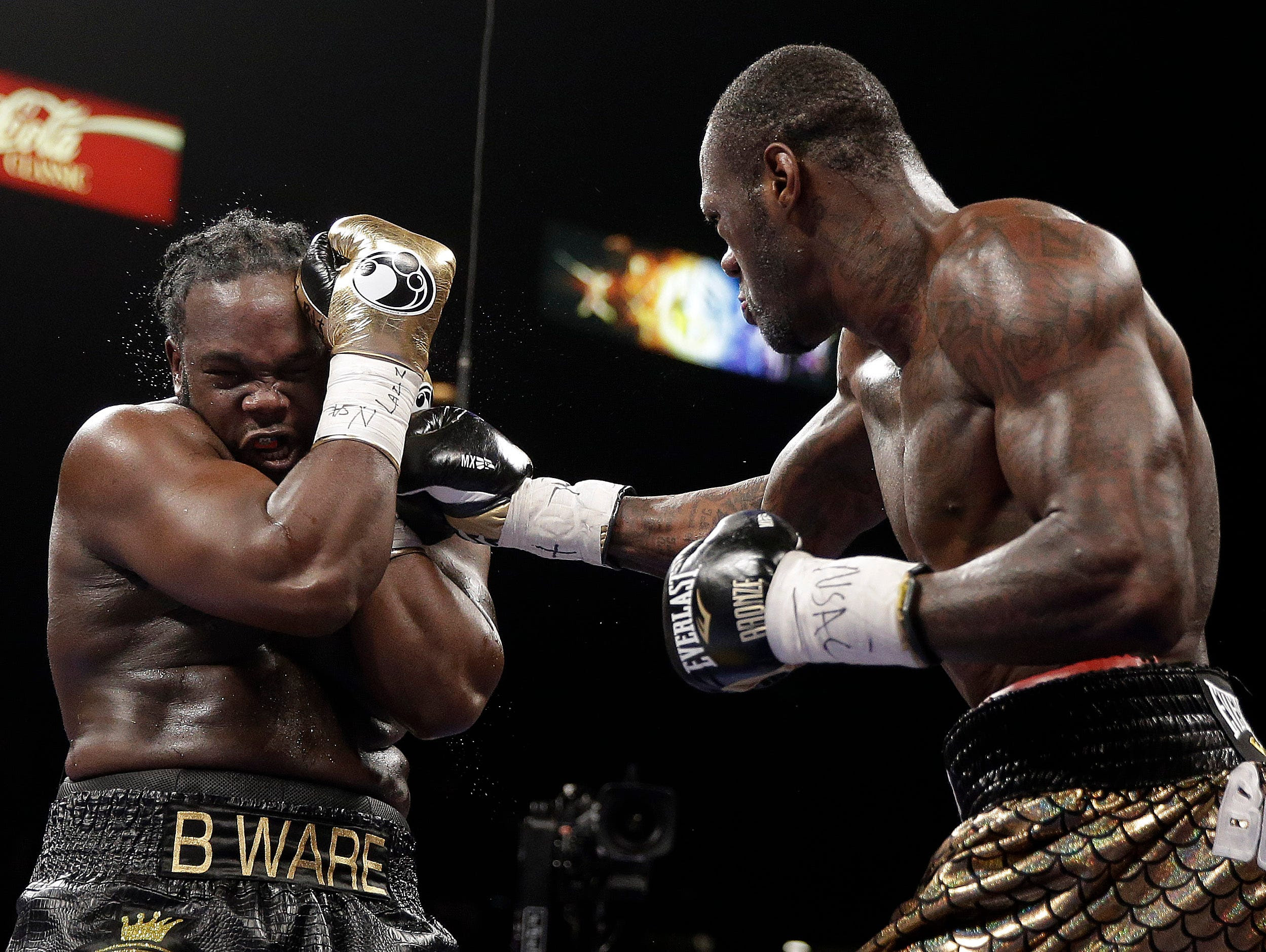 Deontay Wilder, right, punches Bermane Stiverne during their WBC heavyweight championship fight Saturday. Wilder becomes the first American heavyweight champ since 2006.