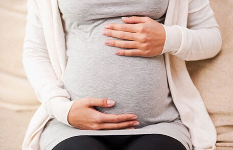Un bebé recostado en el vientre de una mujer embarazada