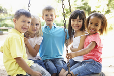 photograph of five children on playground equipment