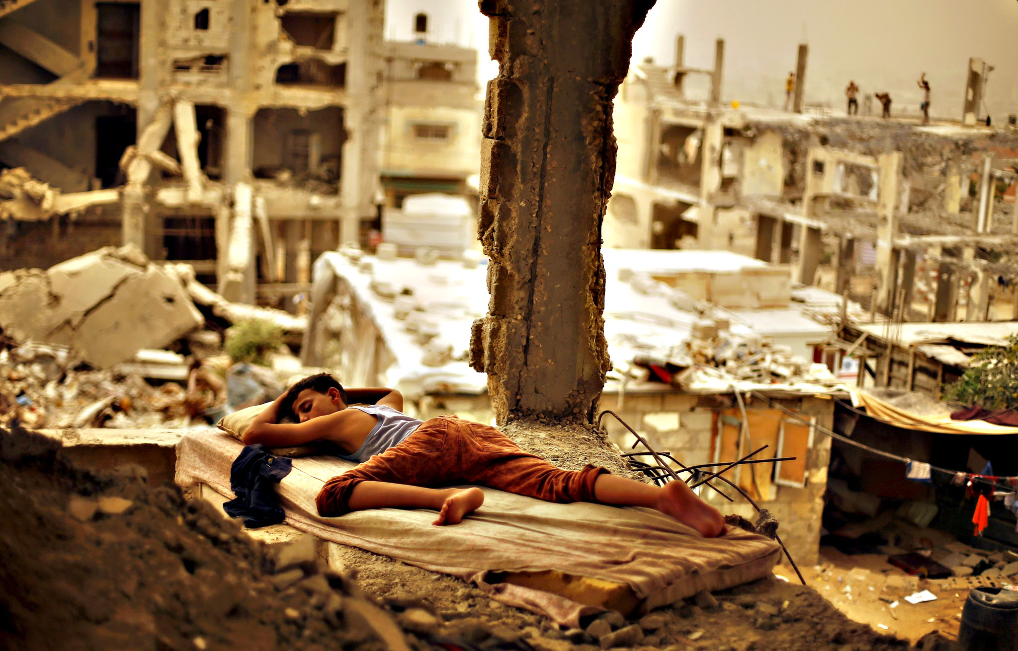 A Palestinian boy sleeps on a mattress inside the remains of his family's house, that witnesses said was destroyed by Israeli shelling during a 50-day war in 2014 summer, during a sandstorm in Gaza September 8, 2015. A heavy sandstorm swept across parts of the Middle East on Tuesday, killing two people and hospitalising hundreds in Lebanon and disrupting fighting and air strikes in neighbouring Syria. Clouds of dust also engulfed Israel, Jordan and Cyprus where aircraft were diverted to Paphos from Larnaca airport as visibility fell to 500 metres