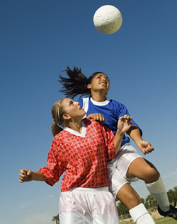 Girls Heading Soccer Ball During Match