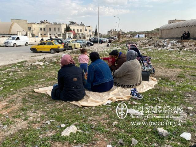 people sitting on ground displaced from the earthquake in Turkey and syria