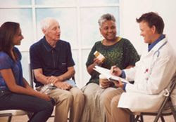 photo of a doctor speaking with three patients. all are seated.