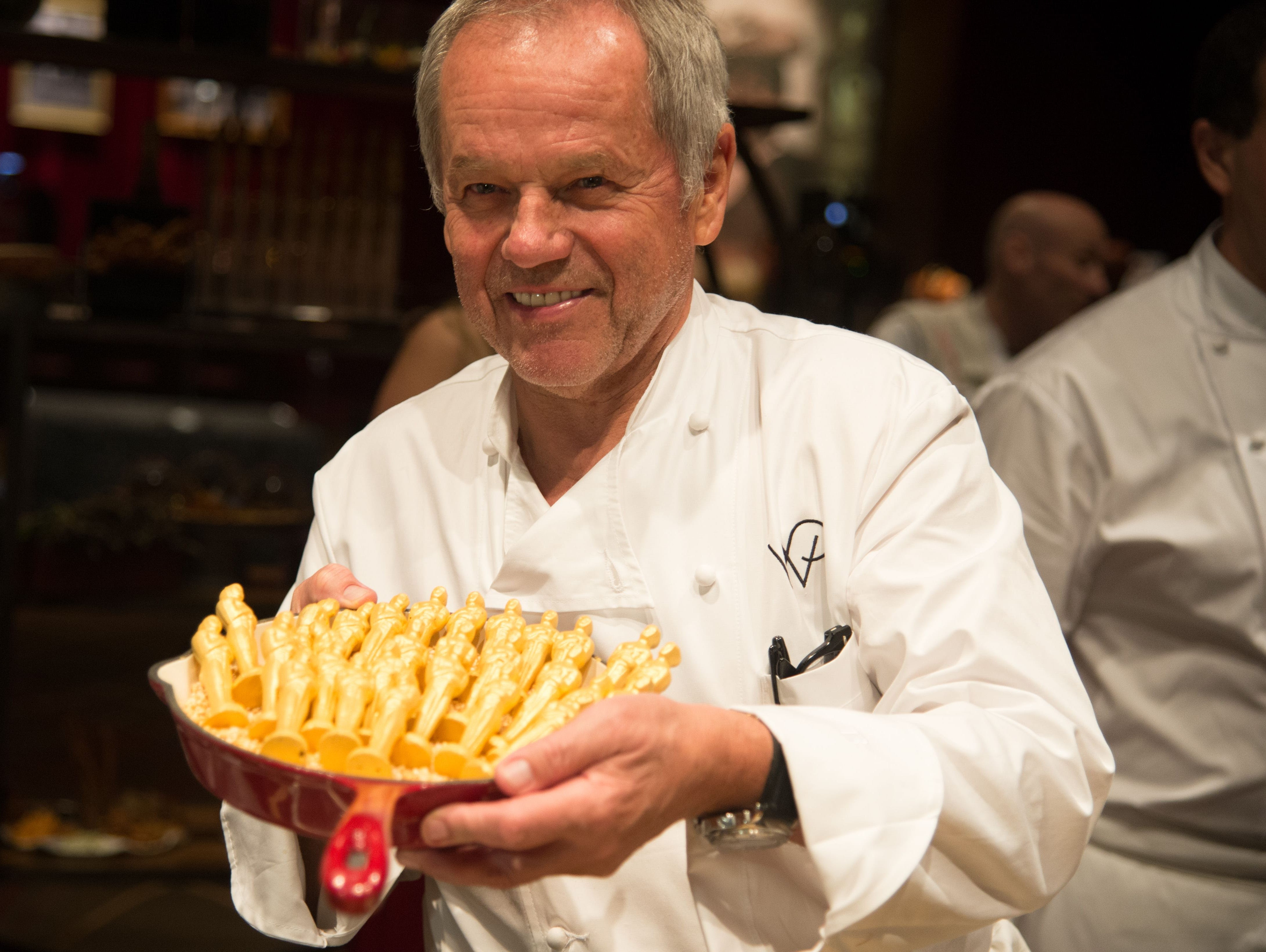 Chef Wolfgang Puck displays chocolate covered Oscar statuettes at the food and decor preview of the 2015 Governors Ball, the post-Oscar celebration.