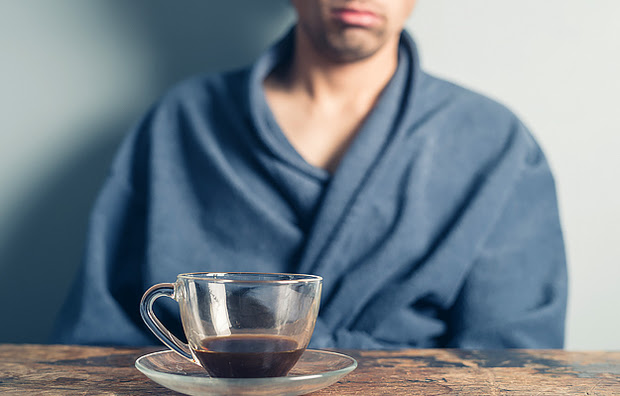 A tired man drinking coffee.