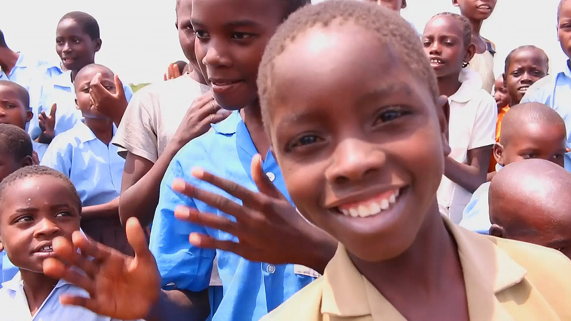 A smiling child in front of a group of friends.