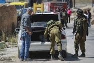 IDF soldiers search vehicle at a Hebron checkpoint. (archive)