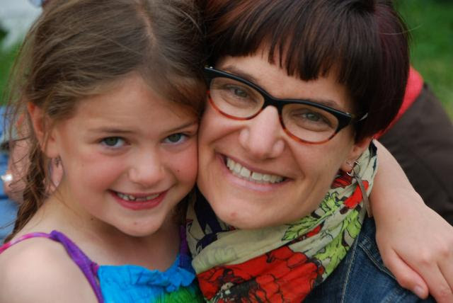 Photo of a smiling child hugging her caregiver.