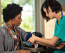 Healthcare professional checking the bloodpressure of a woman