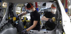 Employees of Toyota, wear protective facemasks and gloves as they work on vehicles at the assembly line of the Toyota automobile plant in Onnaing, near Valenciennes, on April 23, 2020, as the factory reopened after more than a month break aimed at curbing the spread of the COVID-19 (novel coronavirus). (Photo by FRANCOIS LO PRESTI / AFP)