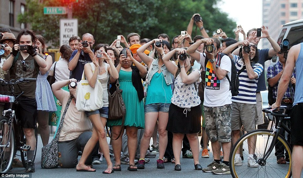 Capturing the moment: The spectacle drew a crowd of snappers yesterday as the sun turned from yellow to pink in perfect alinement's with New York's grid system