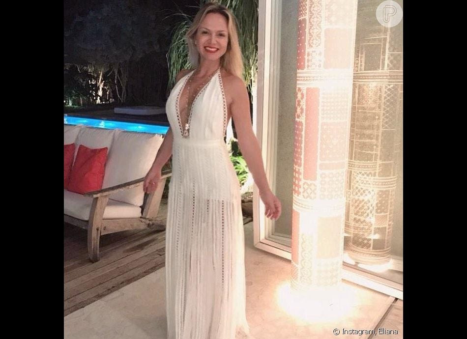 No RÃ©veillon 2019, Eliana usou um vestido longo branco com decote profundo e transparÃªncia elegante