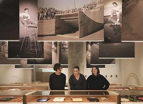 Visitors looking at vitrines inside the Skateboard exhibition space