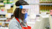 A grocery cashier wears protective equipment to protect against viral transmission. 