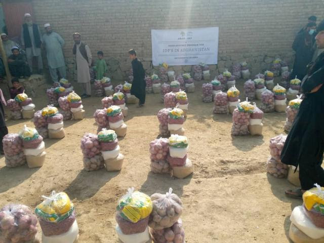 Life saving food packages are arranged on the sandy ground. It is a sunny day.