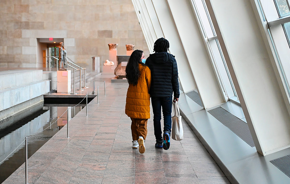 Um casal subindo as escadas do The Met Fifth Avenue para um encontro.